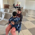 Girl holding toddler at medical clinic