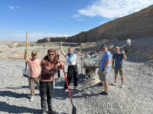 Group poses at the river bed site where they collect gravel