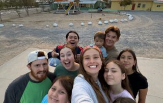 Mission team members posing in front of sunset at Rancho 3M orphanage