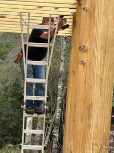 Man on a ladder building a deck