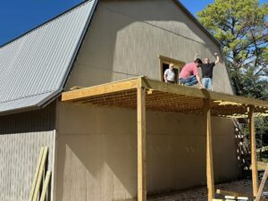 three men working to build a deck