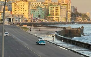 photo of havana showing a road next to the ocean leading to building downtown